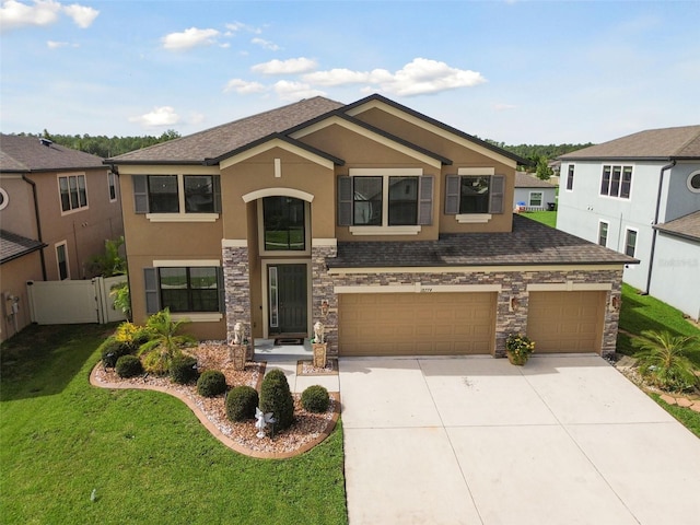 view of front of house with stucco siding, concrete driveway, a front yard, fence, and a garage