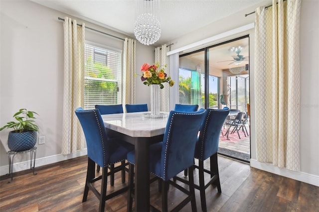 dining space with dark wood-style floors, baseboards, and ceiling fan with notable chandelier