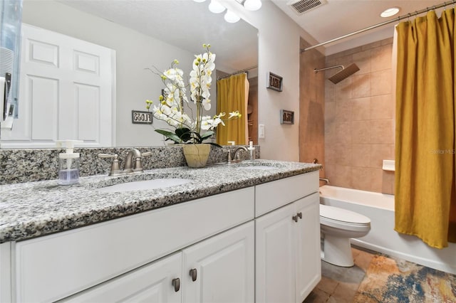 full bathroom with visible vents, a sink, toilet, and double vanity