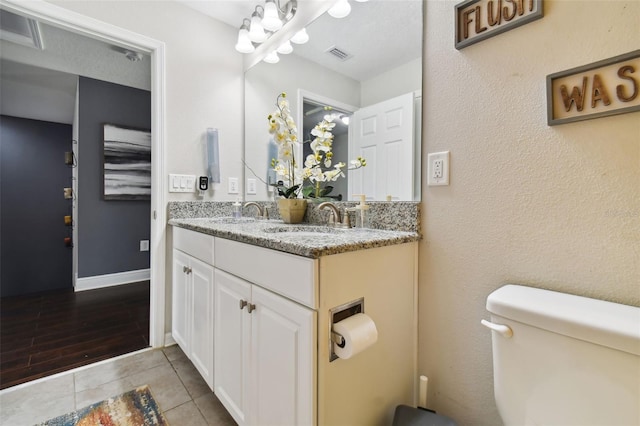 bathroom with toilet, visible vents, a sink, and tile patterned floors