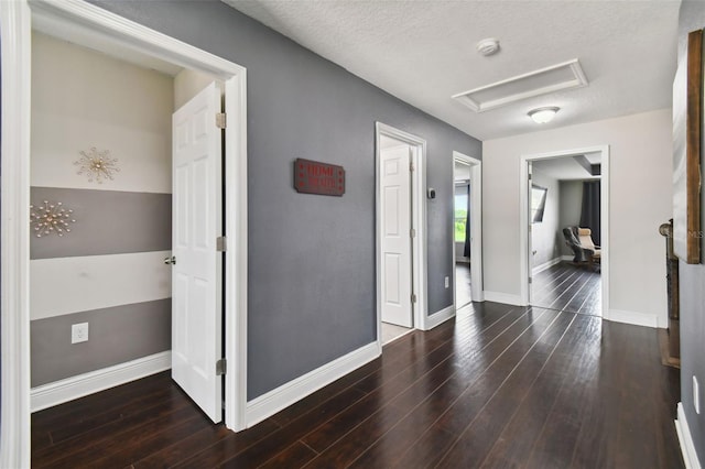 hall featuring a textured ceiling and dark hardwood / wood-style flooring