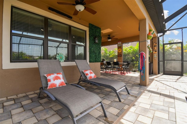 view of patio featuring ceiling fan, outdoor dining space, and a lanai