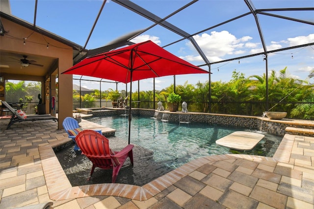 view of pool featuring a ceiling fan, a pool with connected hot tub, glass enclosure, and a patio