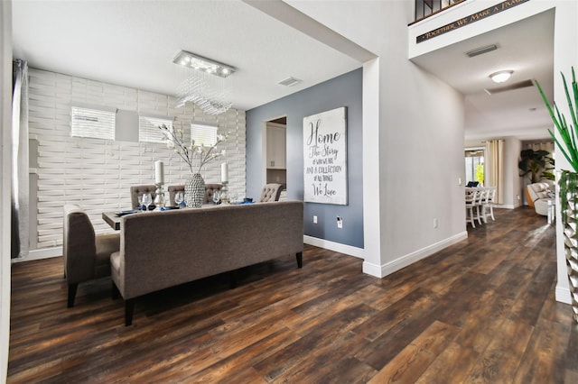 living area with visible vents, baseboards, and wood finished floors