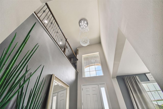 foyer featuring a towering ceiling and an inviting chandelier