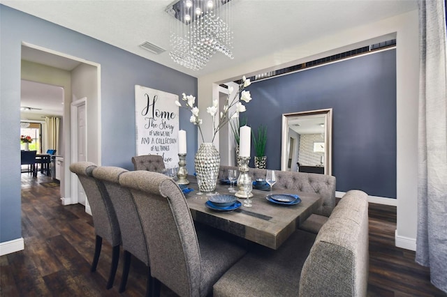 dining area with wood finished floors, visible vents, baseboards, and an inviting chandelier