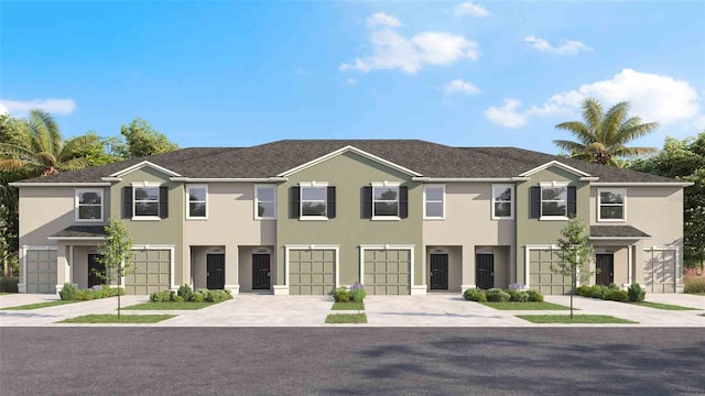 view of property featuring stucco siding, driveway, and a garage