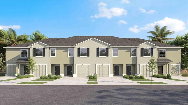 view of property featuring stucco siding, an attached garage, and driveway