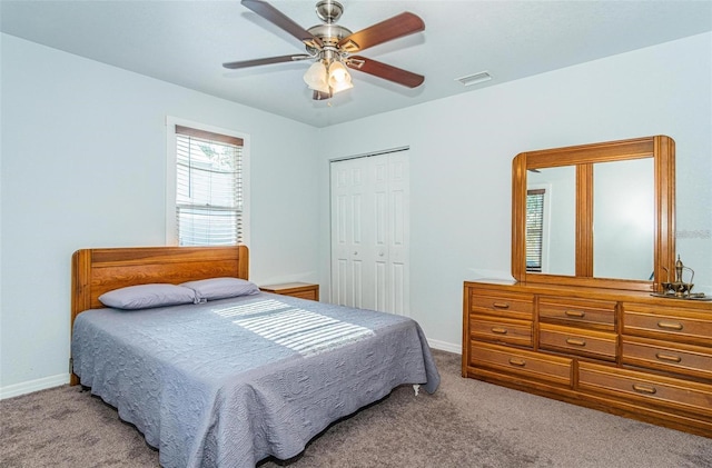 carpeted bedroom featuring ceiling fan and a closet