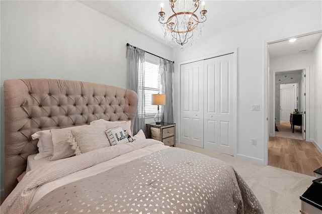 carpeted bedroom with a closet and an inviting chandelier