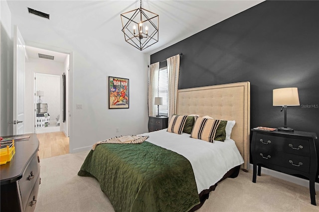 bedroom with light carpet and a chandelier