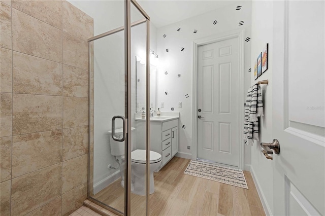 bathroom featuring wood-type flooring, vanity, toilet, and walk in shower