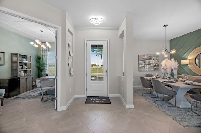 entrance foyer featuring light tile patterned floors, ornamental molding, and an inviting chandelier