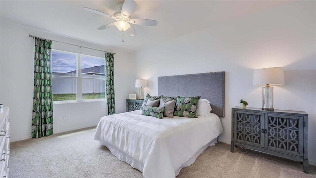 bedroom featuring light colored carpet and ceiling fan