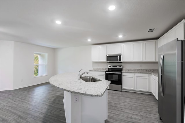 kitchen with white cabinetry, sink, stainless steel appliances, a kitchen island with sink, and hardwood / wood-style flooring