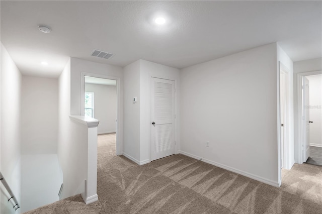 interior space featuring light carpet and a closet