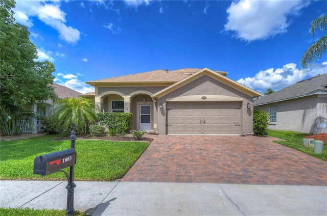 view of front of home with a front yard and a garage