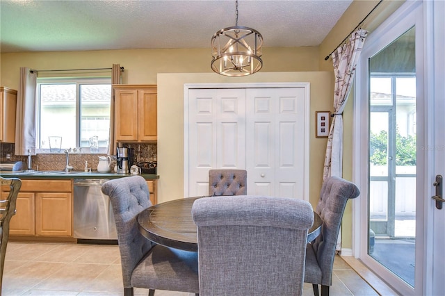 dining room with a wealth of natural light, light tile patterned flooring, and an inviting chandelier