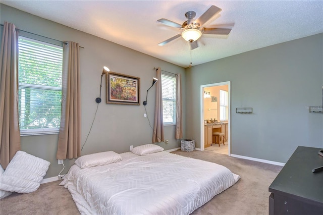 carpeted bedroom featuring ceiling fan and ensuite bathroom