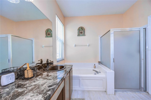 bathroom with vanity and shower with separate bathtub