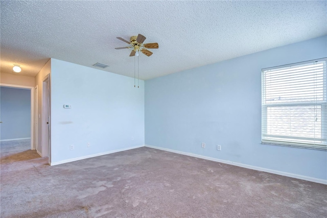 carpeted empty room with ceiling fan and a textured ceiling