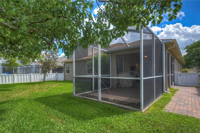 back of house with a lawn and a lanai