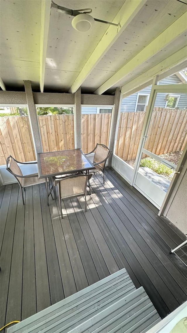 unfurnished sunroom with beam ceiling