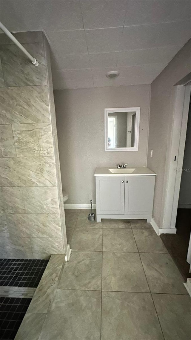 bathroom with tile patterned floors, a shower, vanity, and toilet