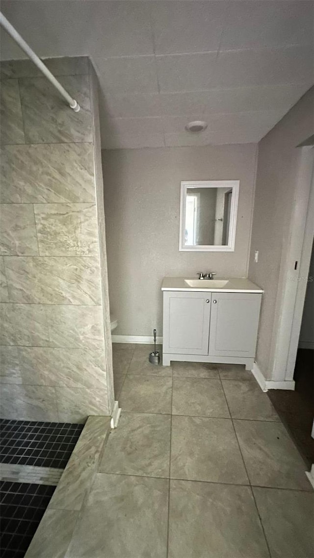 bathroom with a shower, vanity, and tile patterned floors