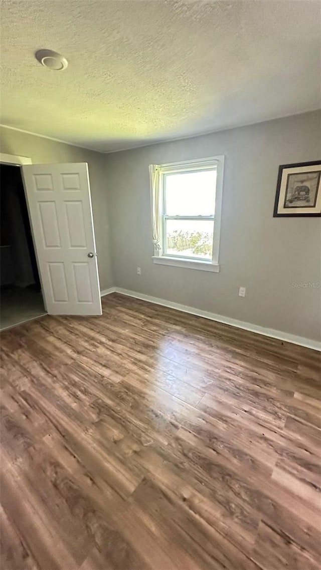 unfurnished bedroom featuring a textured ceiling and hardwood / wood-style flooring