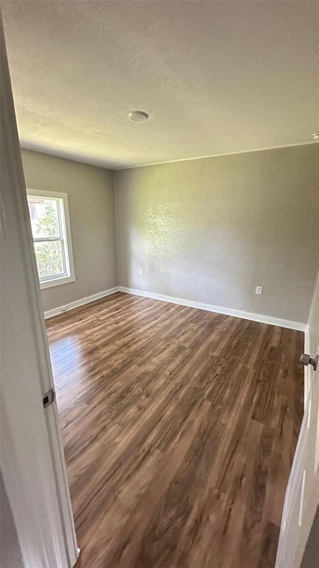 empty room with dark hardwood / wood-style flooring