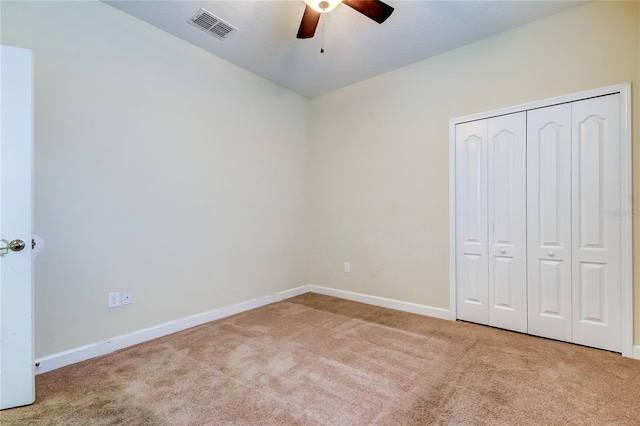 unfurnished bedroom with ceiling fan, a closet, and light colored carpet