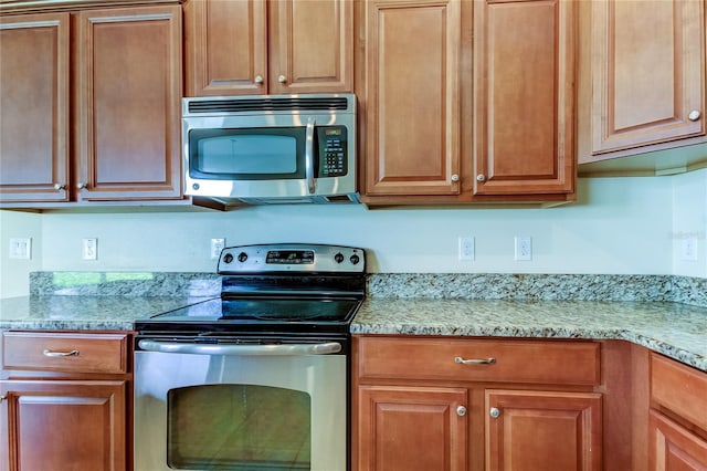 kitchen with light stone countertops and appliances with stainless steel finishes