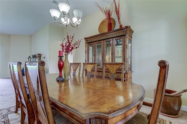 dining area featuring light colored carpet and a notable chandelier