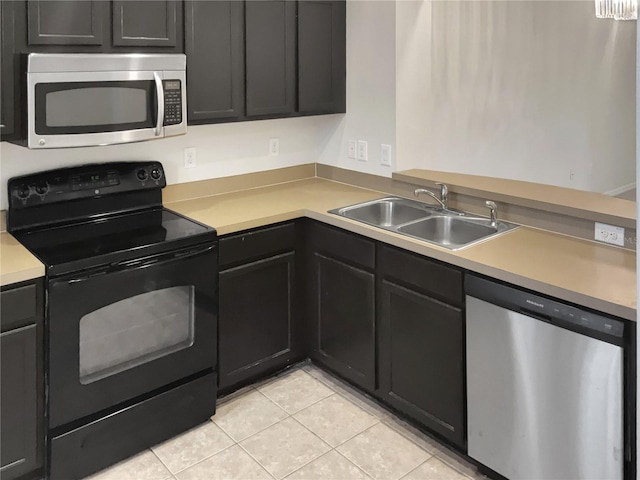 kitchen featuring stainless steel appliances, sink, and light tile floors