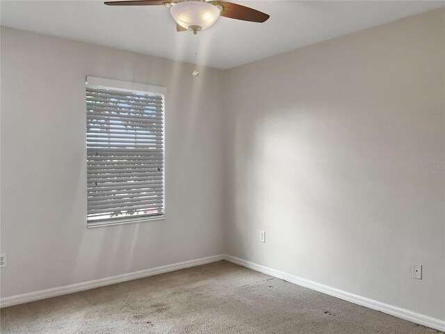 empty room with ceiling fan and carpet floors