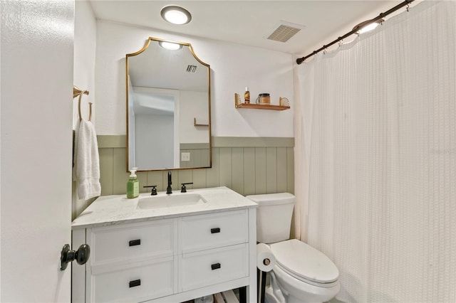 bathroom featuring curtained shower, toilet, and vanity