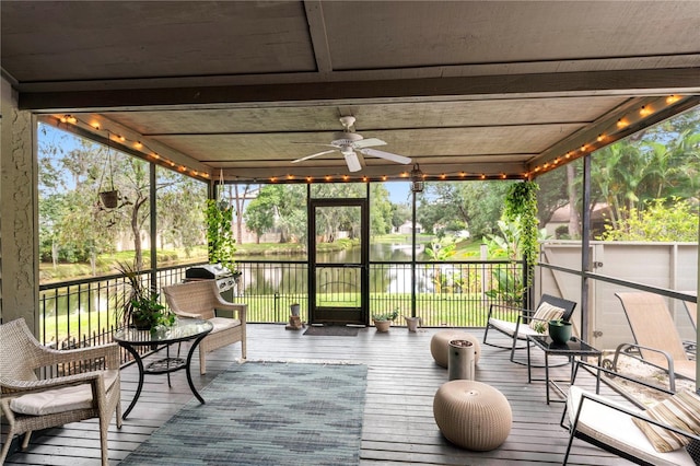 sunroom / solarium with ceiling fan, a wealth of natural light, and a water view