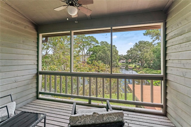 unfurnished sunroom with ceiling fan, a water view, a healthy amount of sunlight, and lofted ceiling