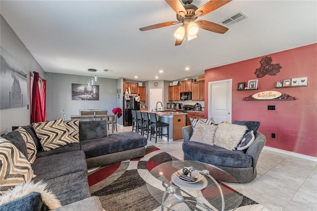 living room featuring ceiling fan, sink, and light tile patterned floors