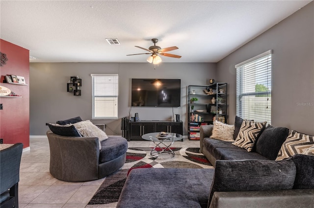 tiled living room featuring a textured ceiling and ceiling fan