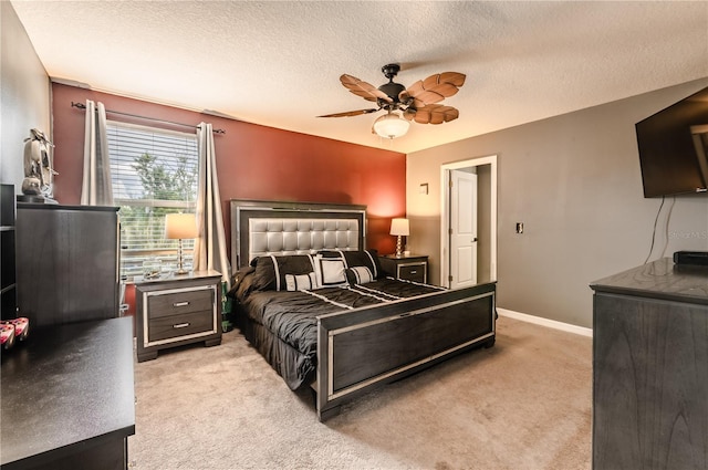 carpeted bedroom with ceiling fan and a textured ceiling