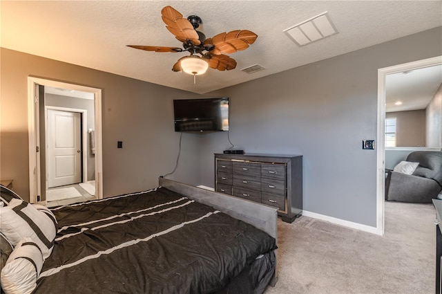 bedroom featuring a textured ceiling, light colored carpet, and ceiling fan