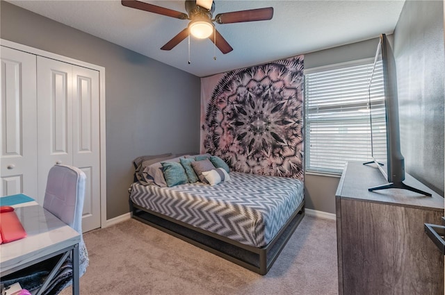 carpeted bedroom with ceiling fan and a closet