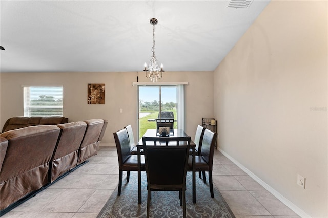 tiled dining room featuring a notable chandelier