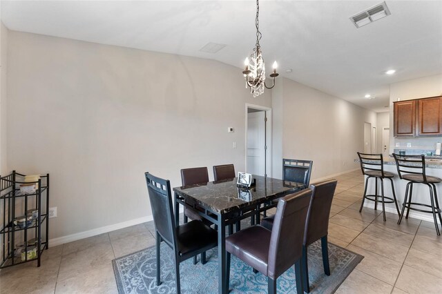 dining area featuring a chandelier, light tile flooring, and lofted ceiling