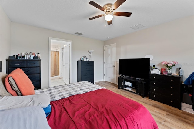 bedroom with ceiling fan, light hardwood / wood-style flooring, and ensuite bath