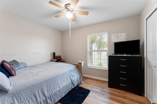 bedroom with light hardwood / wood-style floors, a closet, and ceiling fan