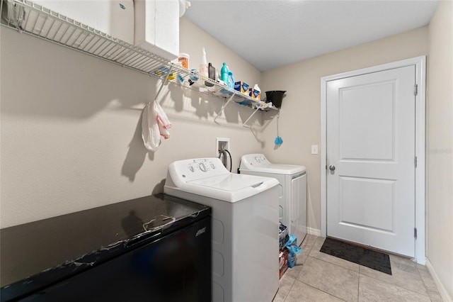 laundry area featuring light tile floors, washer and clothes dryer, and washer hookup