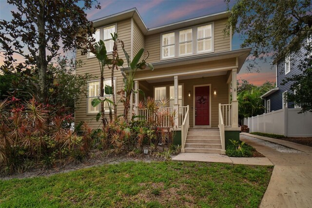 view of front of property with covered porch and fence